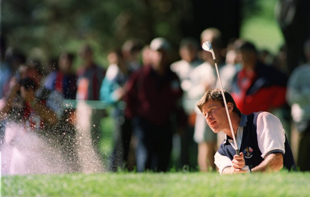 Nick Faldo hits out of a bunker on the fourth hole at Oak Hill during his practice round ahead of the Ryder Cup